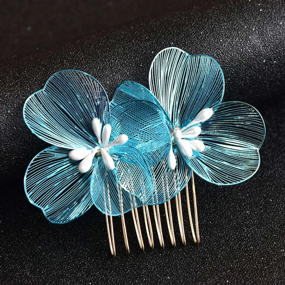 A delicate blue wirework bridal headdress with white center petals and gold-toned base fairy golden flower comb