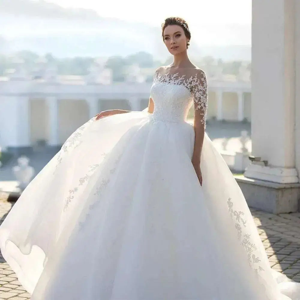 A white bridal gown with intricate lace detailing on the shoulders and sleeves and a voluminous tulle skirt showcased alongside royalessencelux titanium steel jewelry highlighting tummy control fashion and blonde body wave elegance.