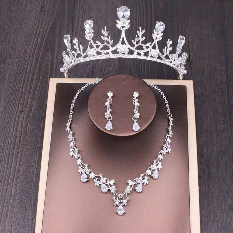 Silver bridal rhinestone crown featuring intricate floral leaf motifs adorned with clear crystals in a crown necklace set