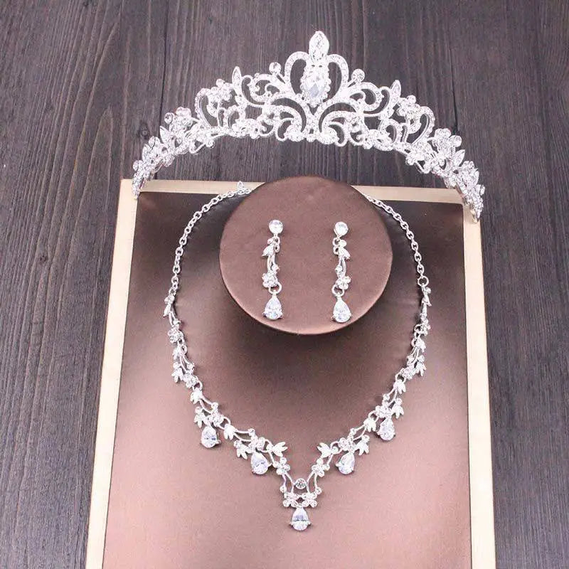 Silver bridal rhinestone crown with intricate floral design and sparkling crystal embellishments in crown necklace set