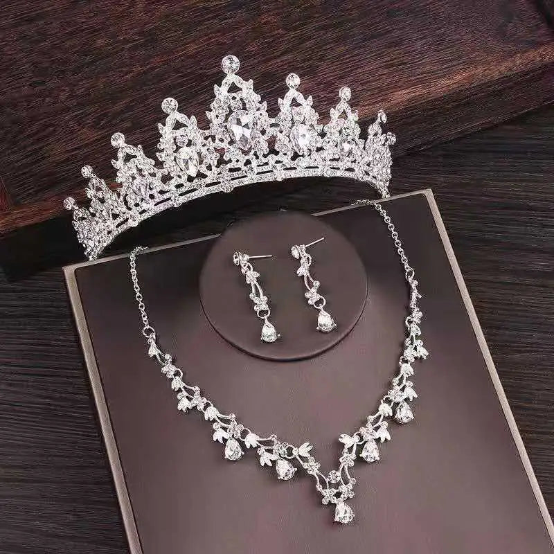 Silver bridal rhinestone crown featuring intricate floral designs and sparkling crystals in a crown necklace set