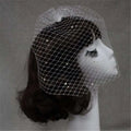 A delicate white bridal veil rhinestone large hole mesh headdress elegantly draped over a mannequin head
