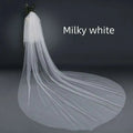 Milky white bridal wedding veil with widened tail made of sheer tulle fabric and attached hair comb for secure wear