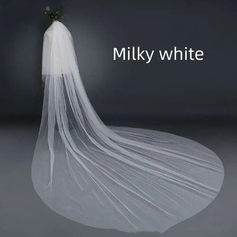 Milky white bridal wedding veil with widened tail made of sheer tulle fabric and attached hair comb for secure wear