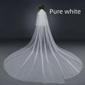 Bridal wedding veil with widened tail made of sheer white tulle fabric gathered at top with attached hair comb