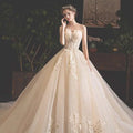 A strapless ivory bride summer tube gown with intricate gold lace appliqués and mori style trailing skirt