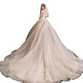 A strapless ivory bride summer tube gown with fitted bodice and mori style trailing skirt featuring gold floral embroidery