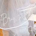 A delicate white tulle bride to be bachelor party bridal comb double layer veil with elegant cursive script