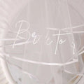 A delicate white tulle double layer veil with bride to be script and bridal comb double for bachelor party bridal use
