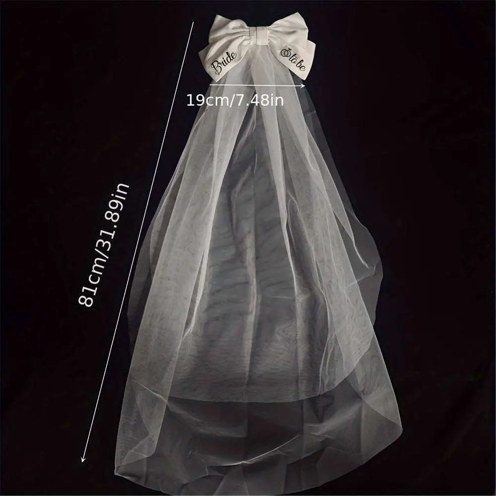 A delicate white tulle bridal veil with a white satin bow and bride to be embroidery for minimalism fashion wedding decoration
