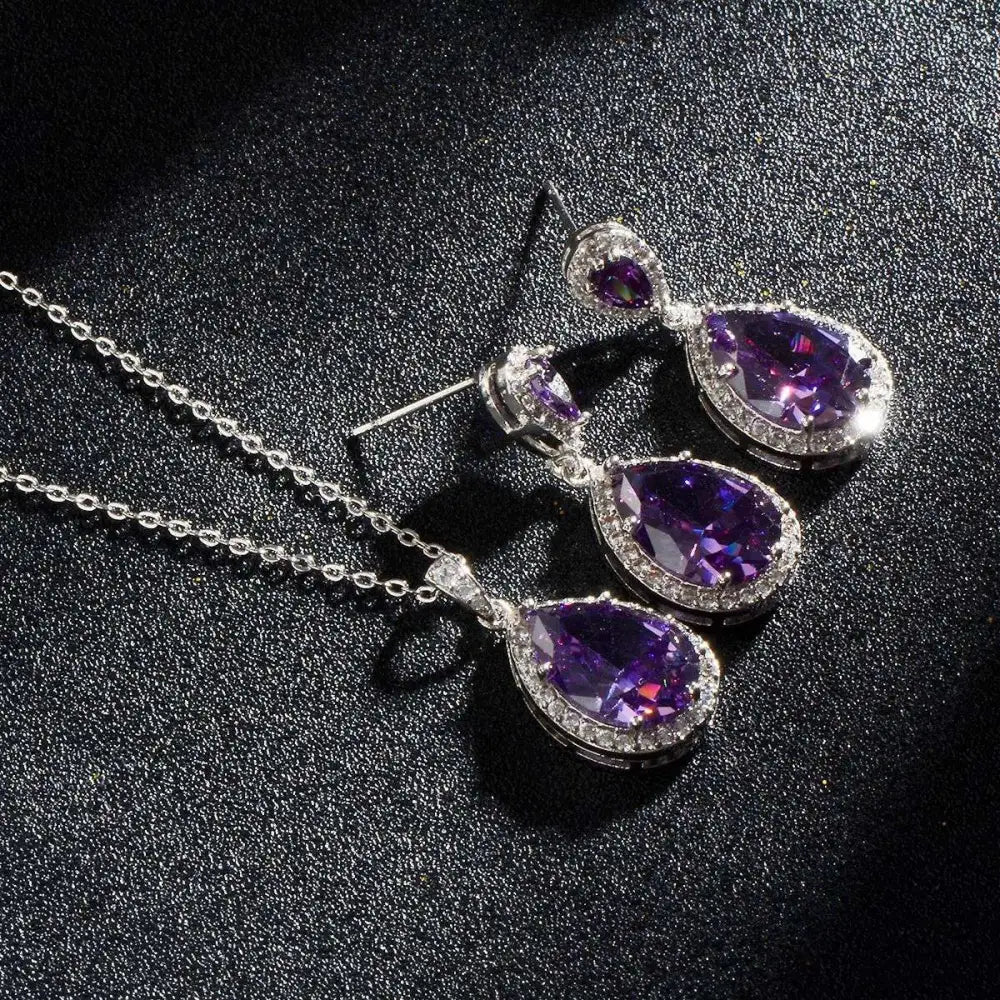 Elegant bright big zircon blue teardrop pendant necklace and matching earrings set with clear gemstones in silver metal