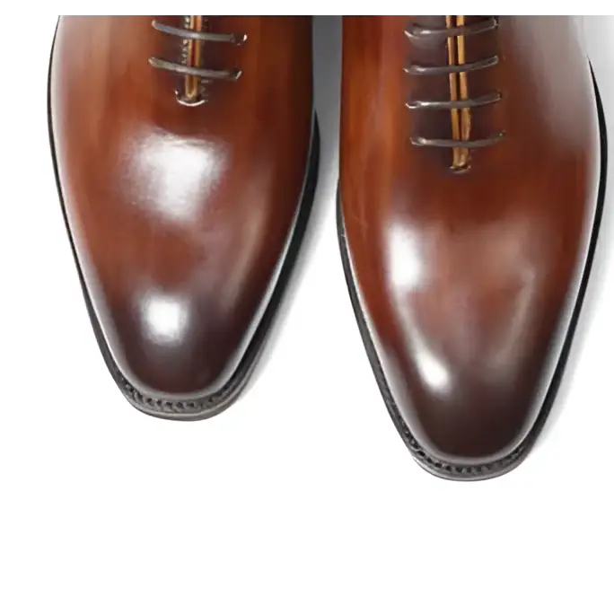 Polished brown leather oxford shoes for men with classic pointed toe and subtle tonal contrast ideal as wedding shoes