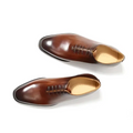 A pair of brown leather oxford shoes for men with classic pointed toe and tan lining ideal as wedding shoes
