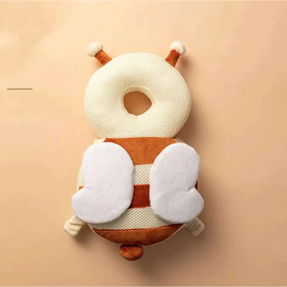Cream and brown plush bee-shaped toddler head protection pad with white wing accents and bunny ear mesh design
