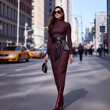A burgundy high neck fitted midi belted dress with a wide-waisted black leather belt tied at the waist