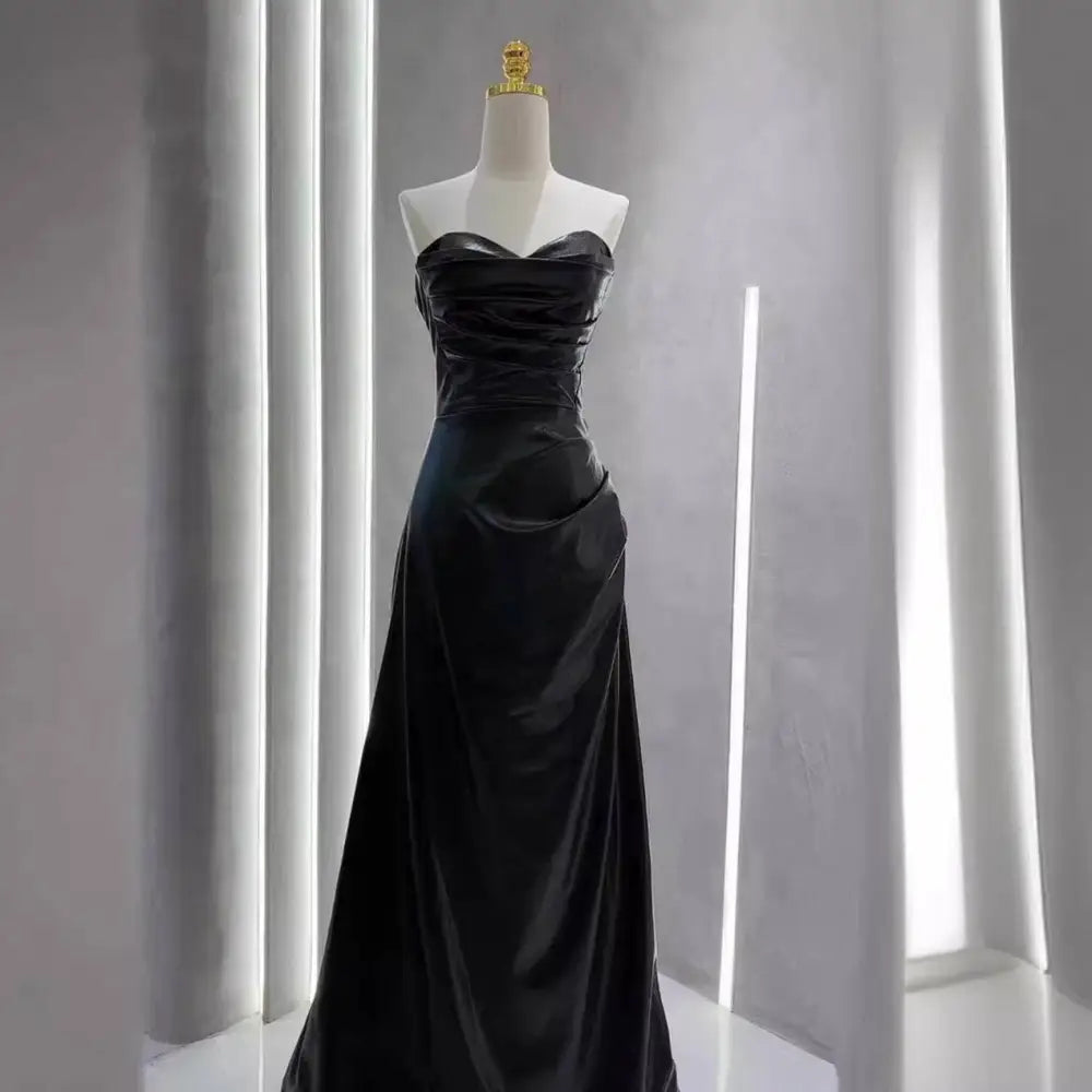 Elegant black satin strapless skirt evening gown with fitted bodice and flowing skirt for formal occasions