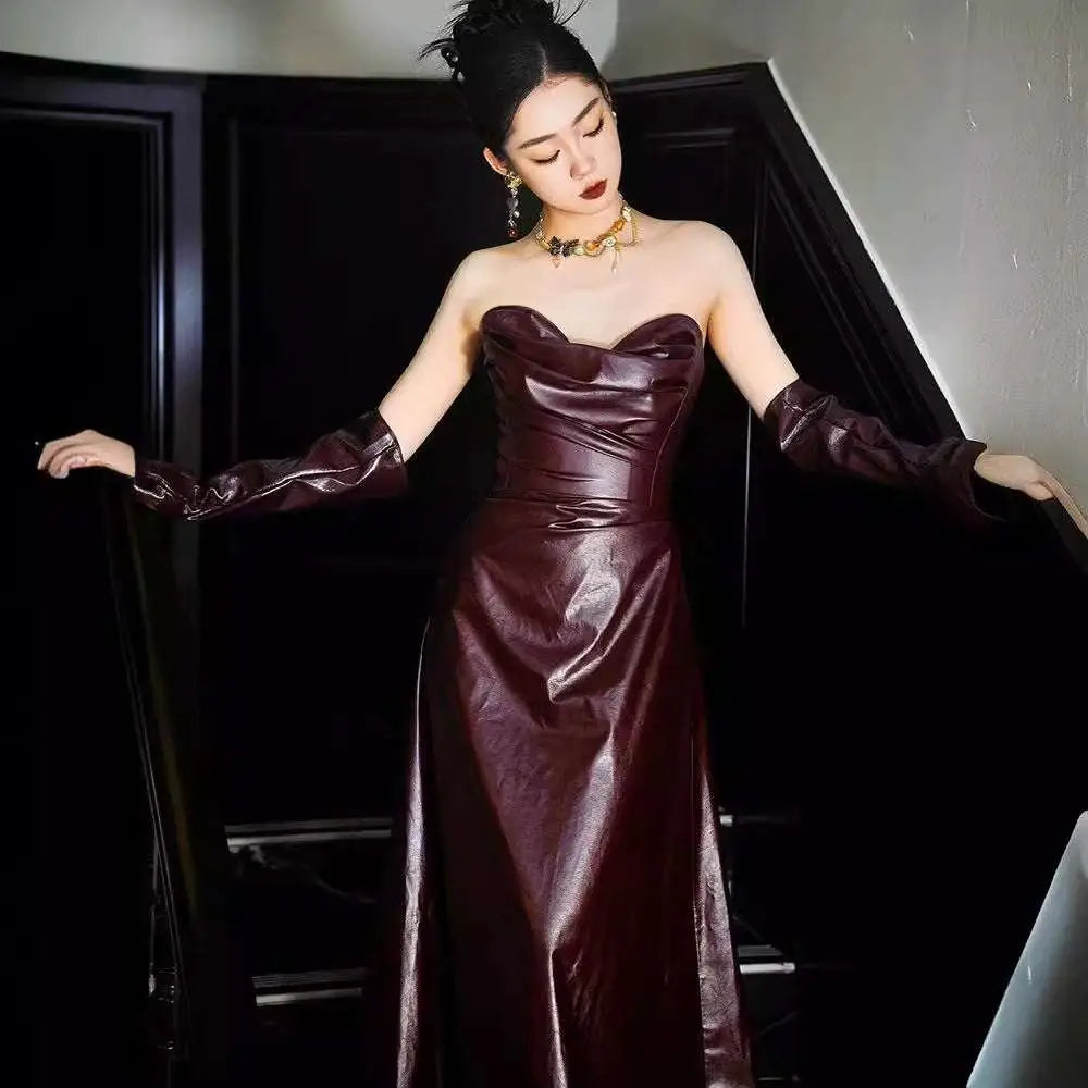 Glossy burgundy leather skirt evening gown with fitted bodice long sleeves and strapless design