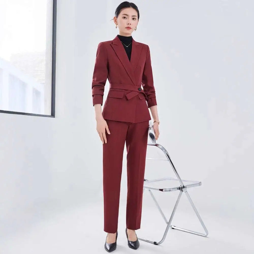 A tailored burgundy long sleeve two piece set with a belted waist blazer and matching sleeve small suit trousers
