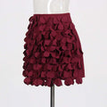A burgundy a line skirt featuring layered petal fabric appliqués with design sense stitching and stitching wafer details