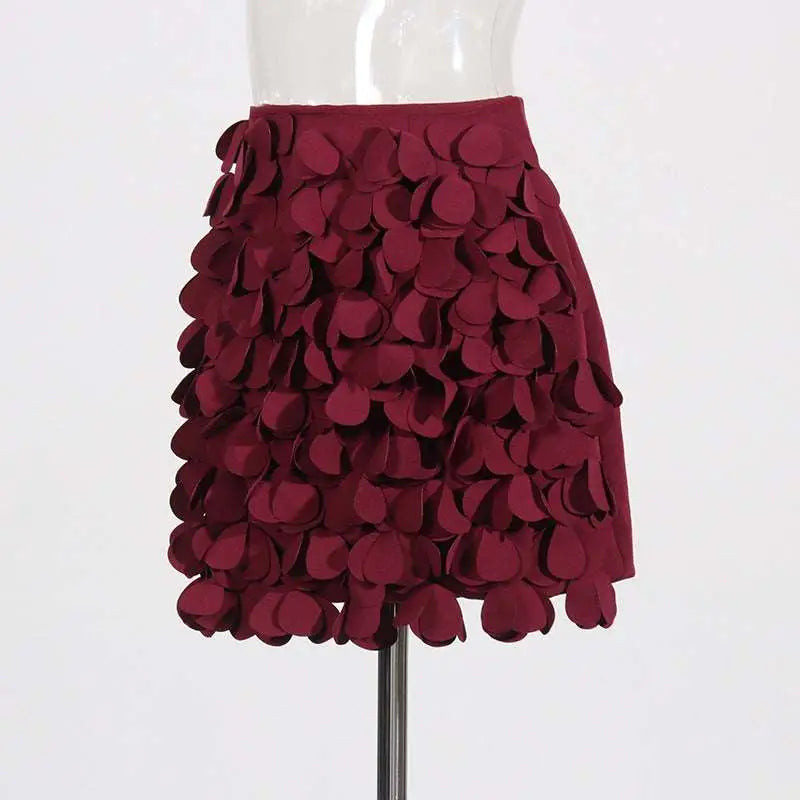 A burgundy a line skirt featuring layered petal fabric appliqués with design sense stitching and stitching wafer details