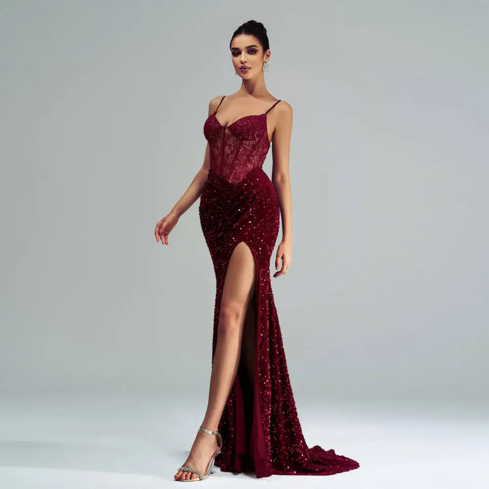 A burgundy sleeveless sequined evening dress with lace bodice and a sequined high slit for formal occasions
