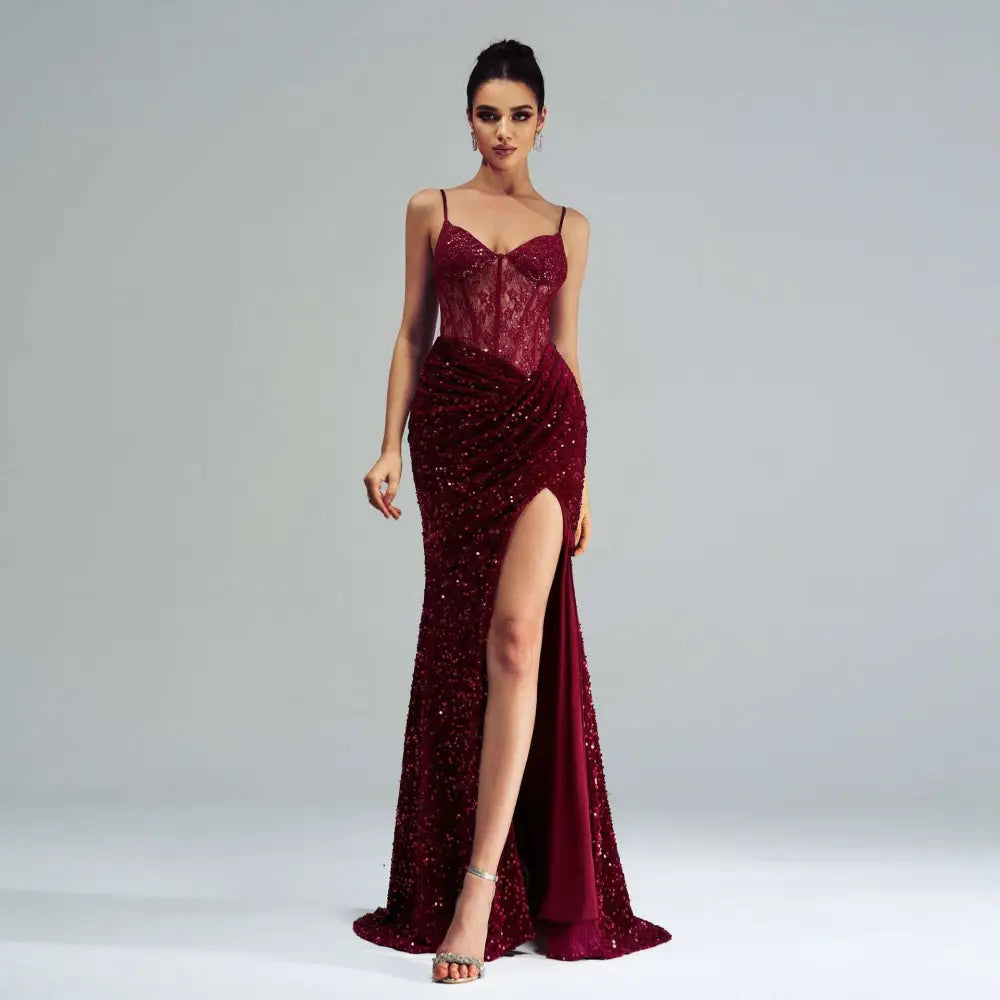 A burgundy sleeveless sequined evening dress with a fitted bodice and a sequined high slit for formal occasions