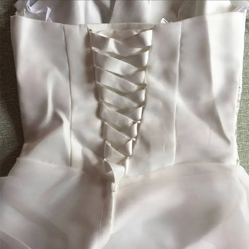 Back view of a white satin bustier korean princess beaded tulle wedding dress with lace-up ribbon detail