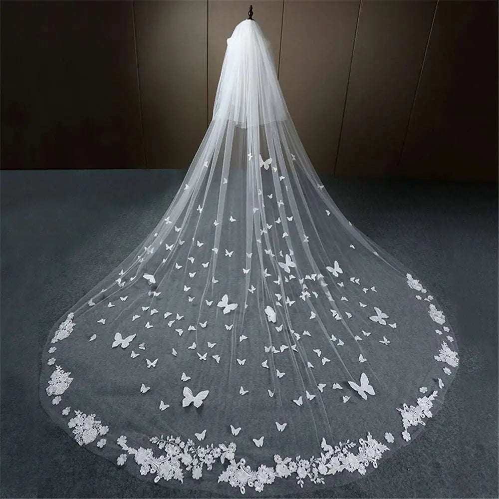 A delicate white butterfly lace sky veil bridal wedding dress with lace floral border and scattered butterfly appliqués