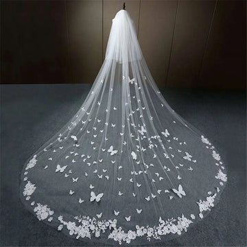 A delicate white butterfly lace sky veil bridal wedding dress with lace floral border and scattered butterfly appliqués