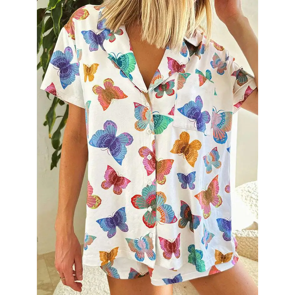 A white short sleeve homewear suit with a vibrant butterfly print in blue purple pink orange and green colors