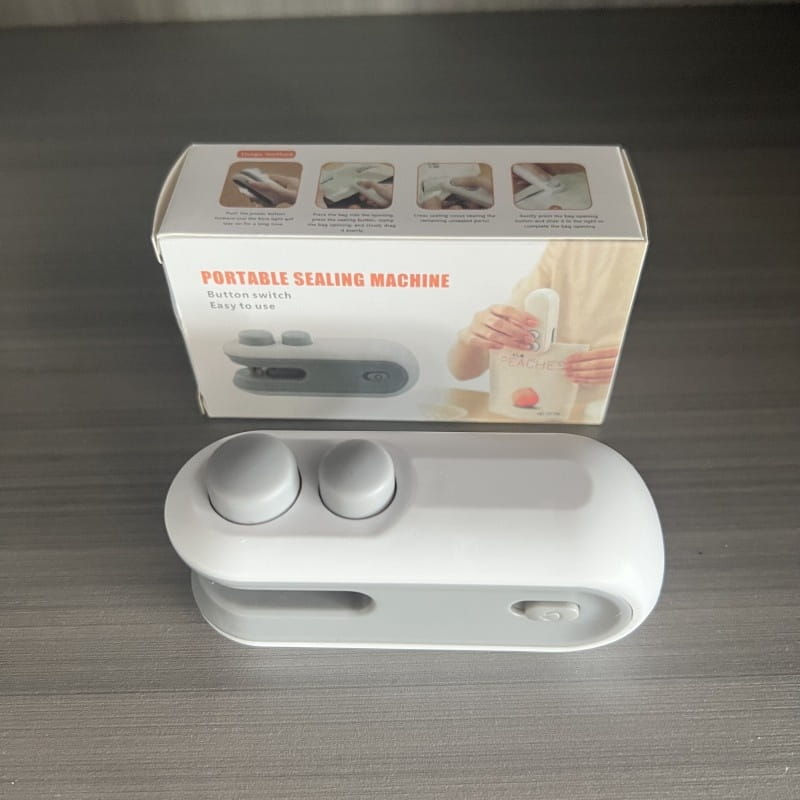 White portable usb heat sealer with two gray circular buttons and a sleek compact design for sealing bags and packaging efficiently.