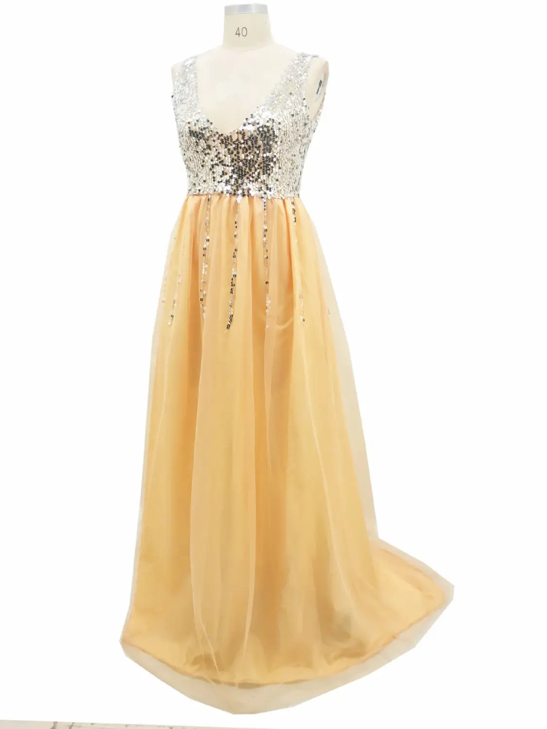 A shimmering peach-colored v-neck sequined floor-length dovetail dress with a sequined bodice and flowing tulle skirt hot sale evening gown.
