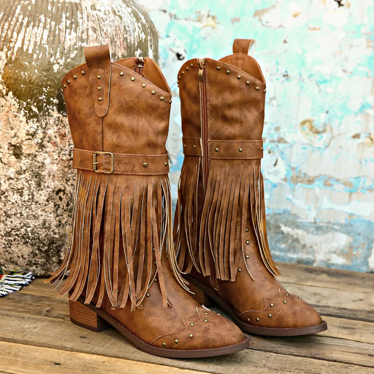 Brown suede cowboy boots with fringe and metal studs featuring a fashion square heel ideal for retro winter fashion.