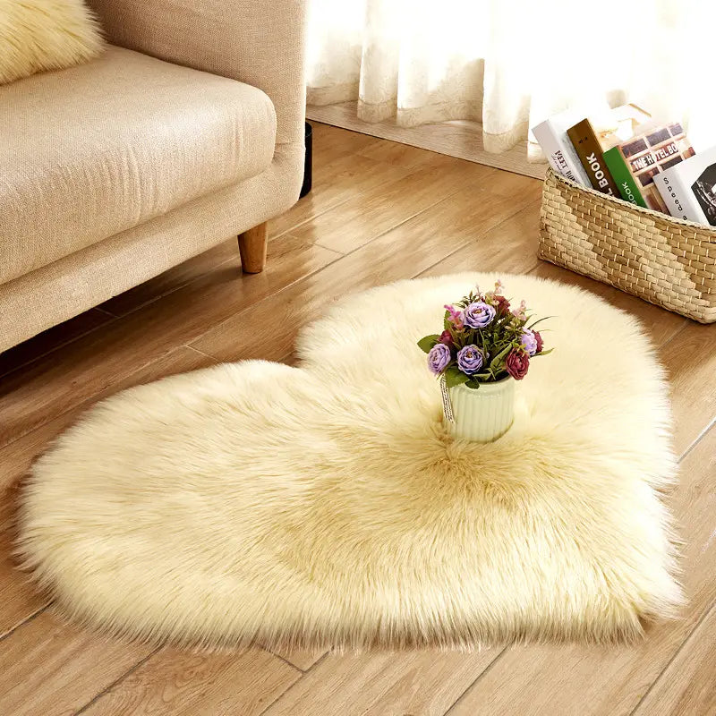 Cream-colored plush heart shaped faux fur living room rug with a soft fluffy texture featuring a central vase of purple and pink flowers.