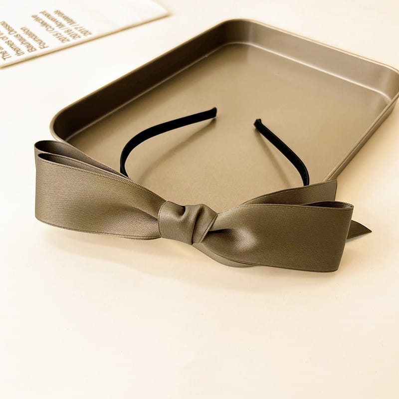 A sleek olive green french satin bow headband featuring a black elastic band for women.