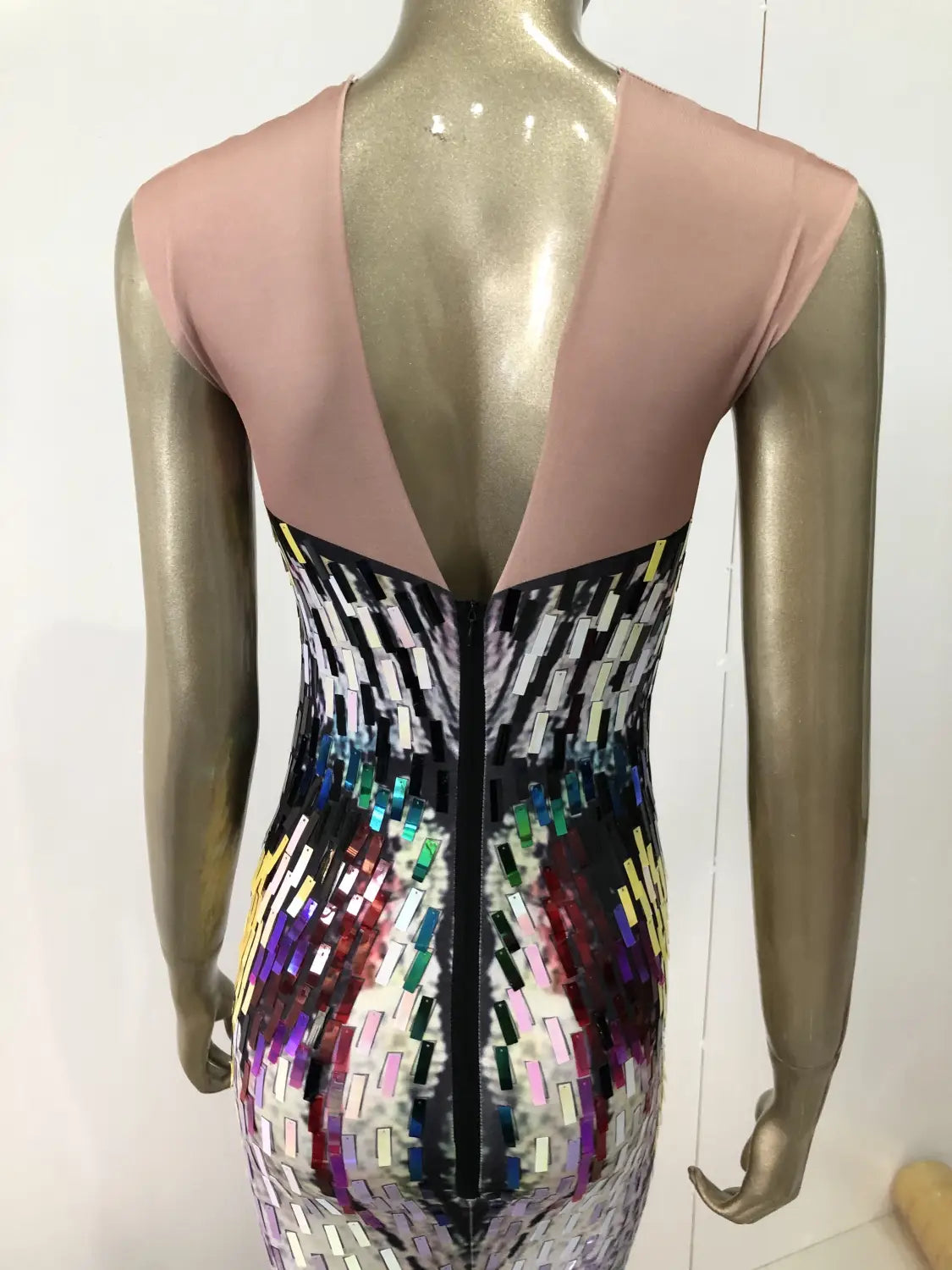 A form-fitting sleeveless sequin evening dress female with a pink mesh back and a vibrant multicolored sequin pattern across the front designed as a dress female singer costume.