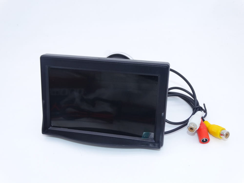 Black rectangular 7 inch suction cup display hd wireless rearview monitor with rca cables for vehicle use shown from the back side.