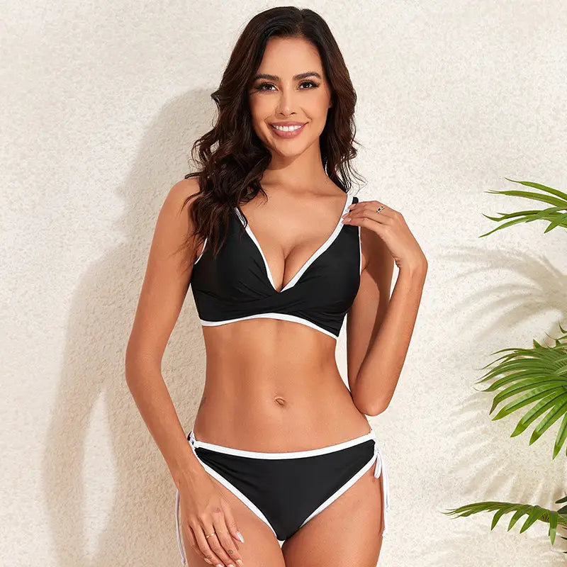 black and white bikini fashion split featuring a two-piece design with a plunging neckline top, thin straps, high-waisted bottoms, and side ties in a fashion split swimsuit style