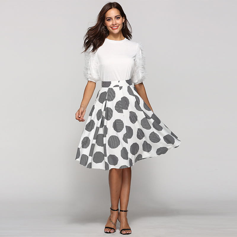 a white and black large polka dot round slim fit a-line skirt with a flared silhouette featuring bold circular patterns in varying sizes