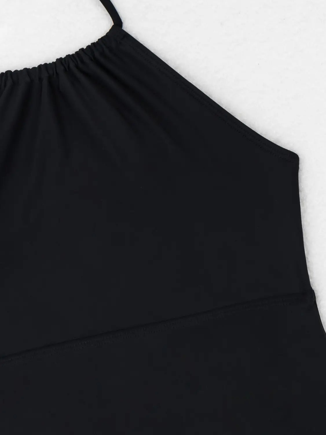 black spaghetti strap top with gathered neckline and smooth stretchy fabric as part of a floral halterneck printed halter split swimsuit.