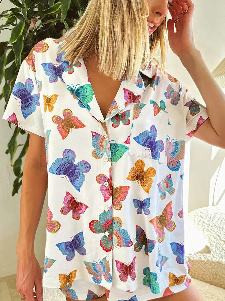 White short-sleeved pajama top with a vibrant all-over rainbow butterfly print designed as a butterfly print short sleeve for comfortable homewear.