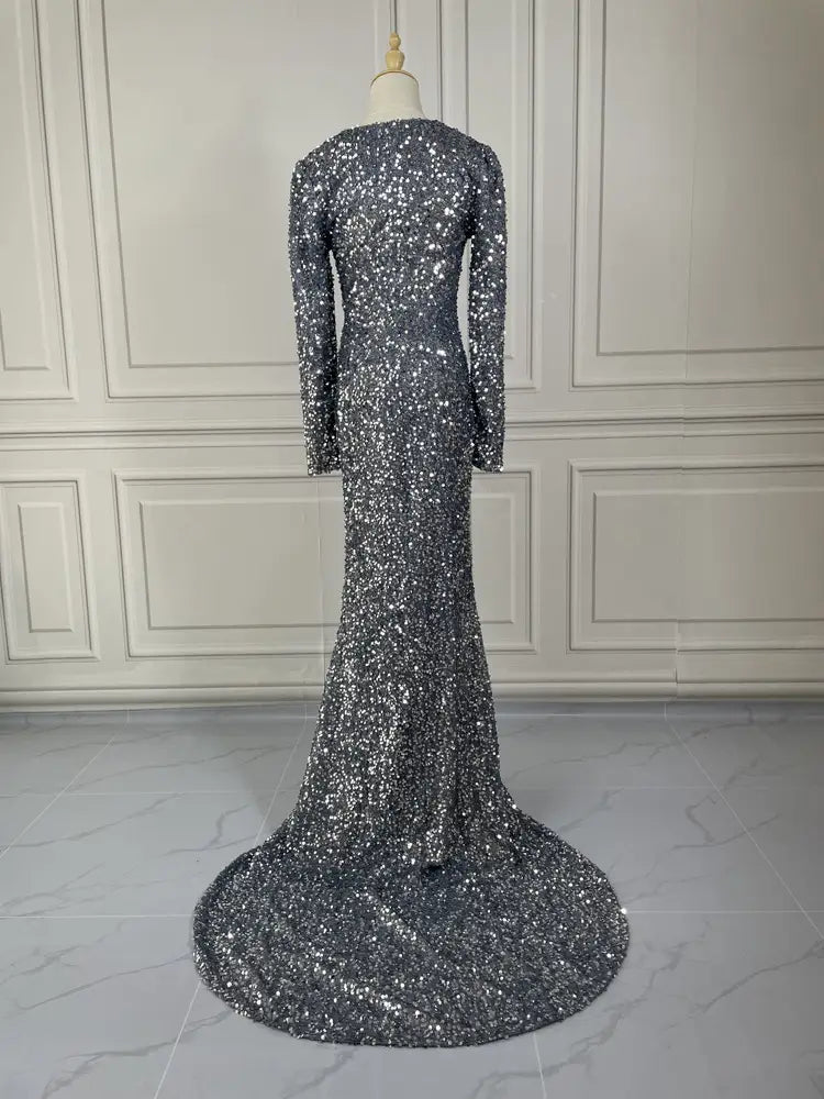 Grey long sleeve sequin mermaid evening dress with shimmering silver sequins, long sleeves, and a flowing train.