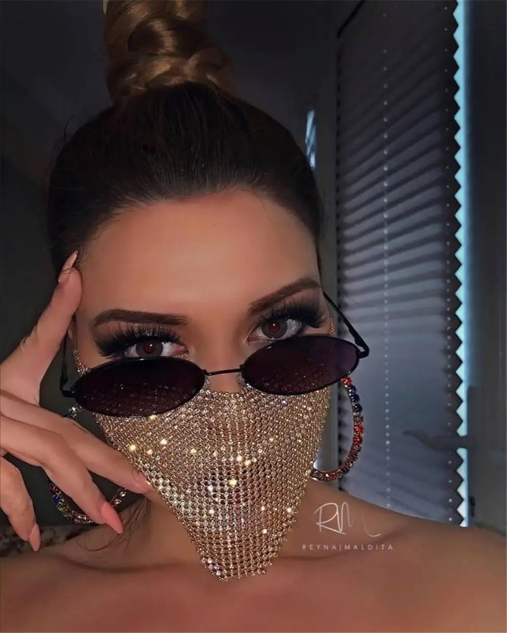 a shimmering gold rhinestone metal flash mesh face mask worn over the nose and mouth featuring a breathable design