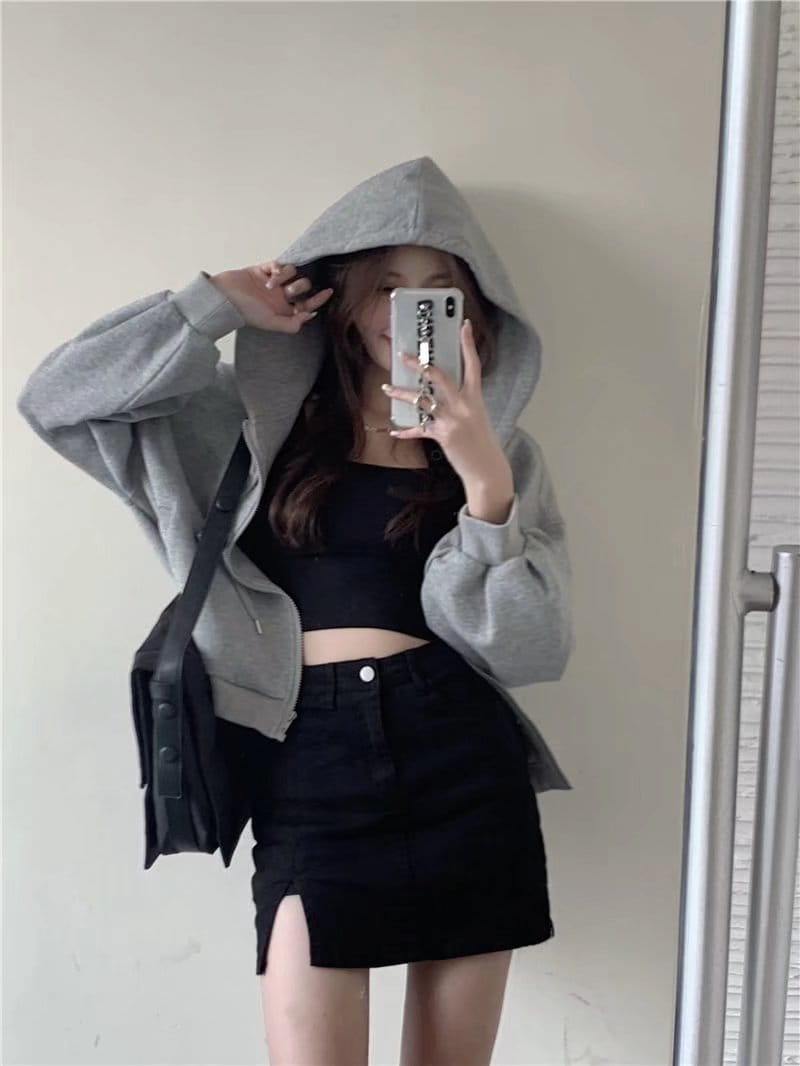gray hooded sweatshirt with loose fit and drawstring detailing paired with distressed black denim skirt featuring a side slit