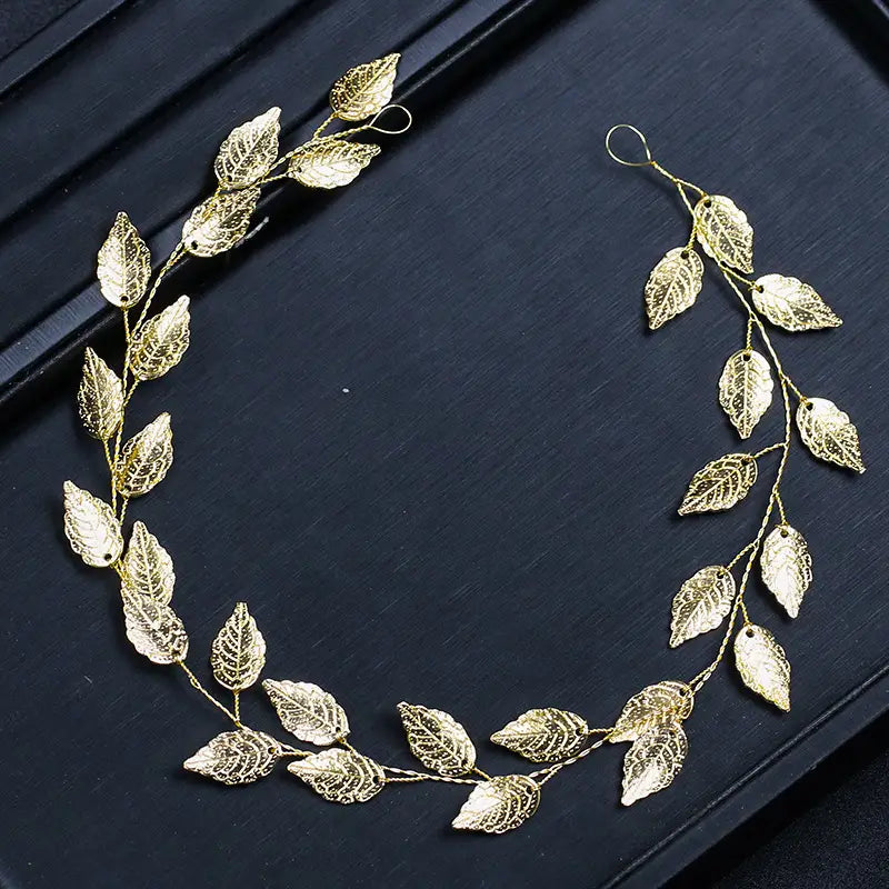 golden leafy headpiece with intricate filigree detailing and delicate wire stems in a gold and silver leaf hair band designed as an elegant leaf hair band accessory.