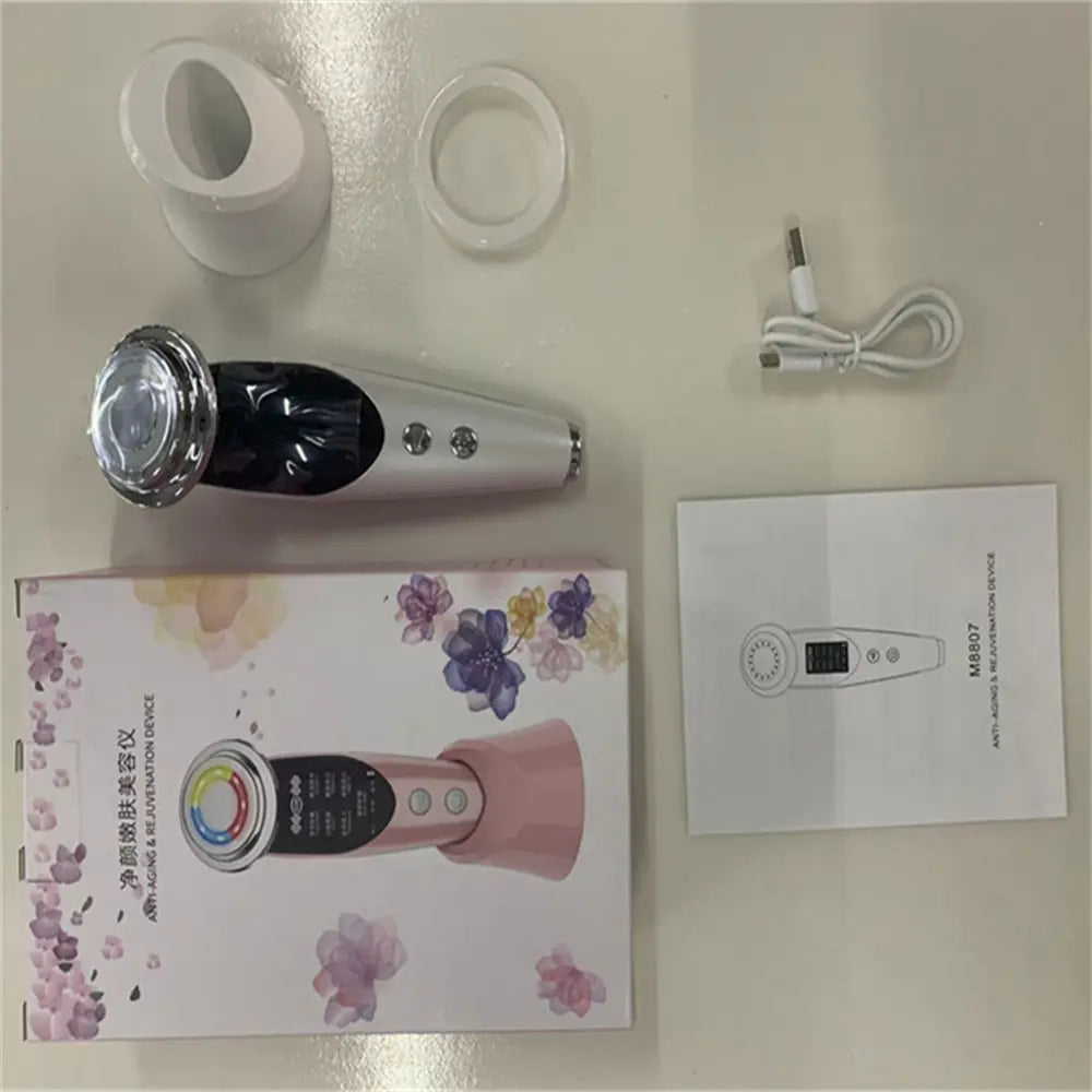 silver and black handheld 7-in-1 facial massager EMS device with a chrome-finished treatment head featuring color light vibration and LED technology