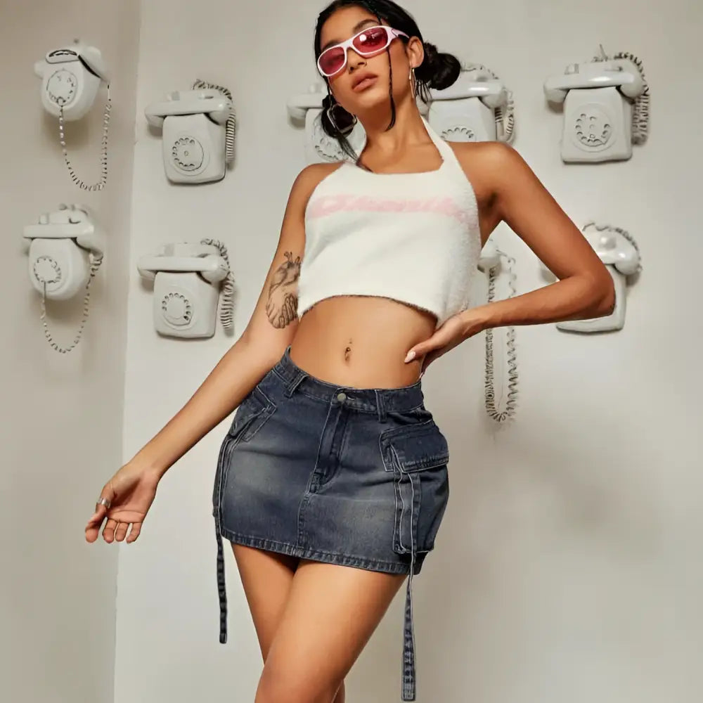 White fuzzy crop top with pink lettering paired with a cargo pocket long denim skirt in a casual outfit setting