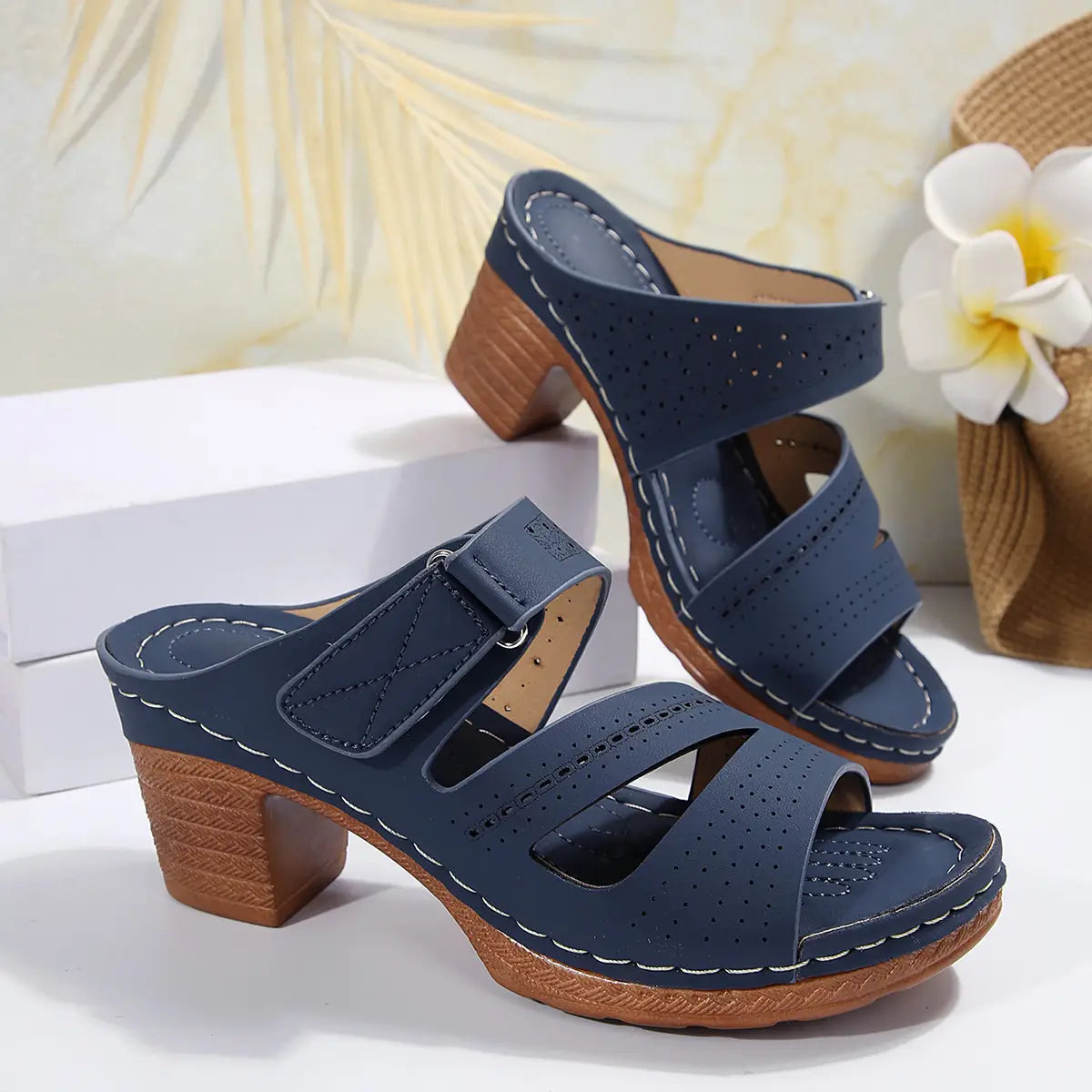 Navy blue perforated leather mule sandals with wooden block heel and white stitching ideal for shoes summer casual and summer casual chunky looks.