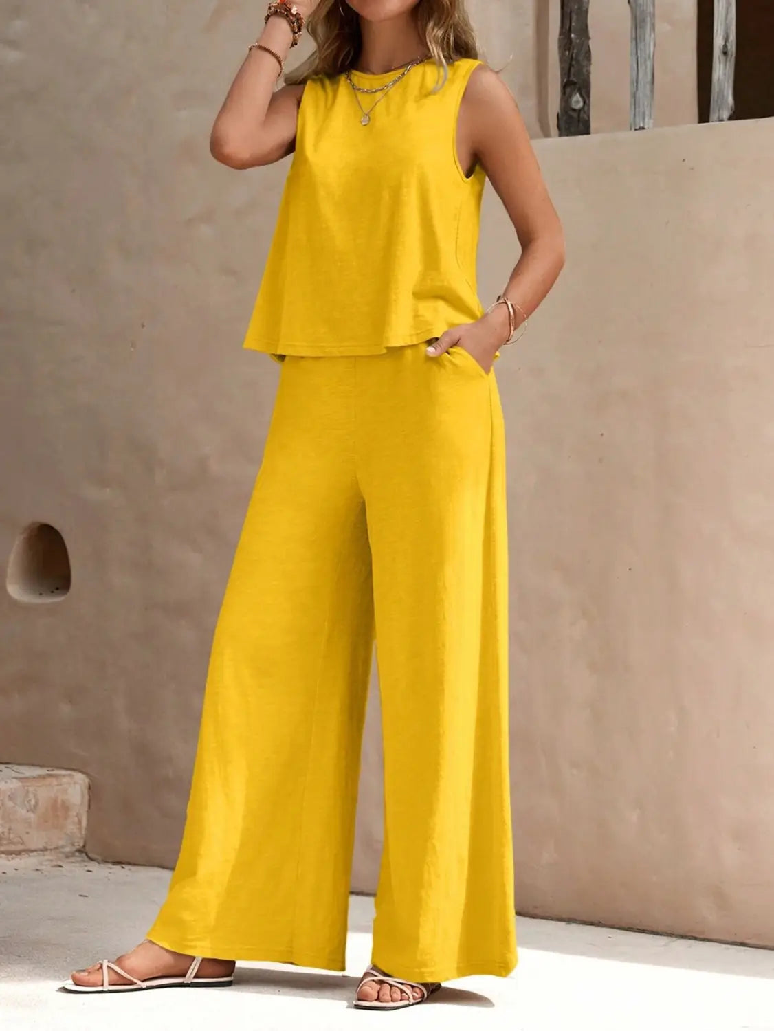 Bright yellow sleeveless top with a flared hem paired with matching casual loose wide-leg pants in a black casual loose pants set.