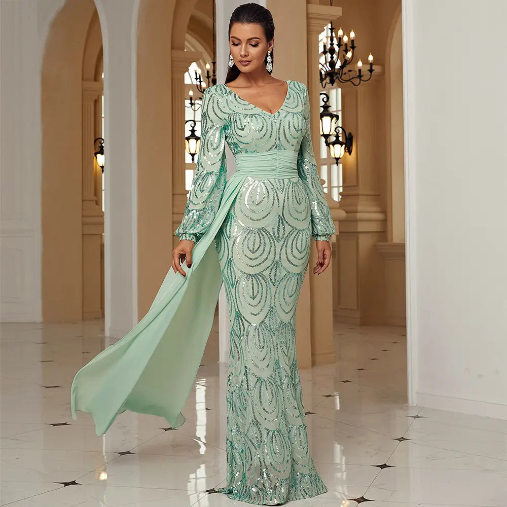 A shimmering mint green long sleeve sexy sequined evening dress with a flowing train.
